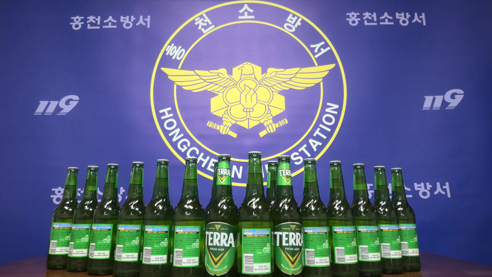 25.3.4.홍천소방서,‘테라 맥주병’에 차량용소화기 비치 홍보라벨 부착1.jpg